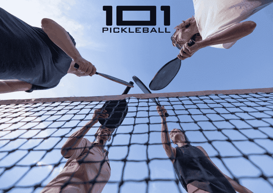 Pickleball players doing paddle tap on the net.