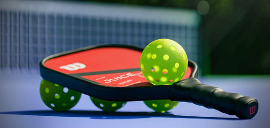 A pickleball paddle with pickleballs.